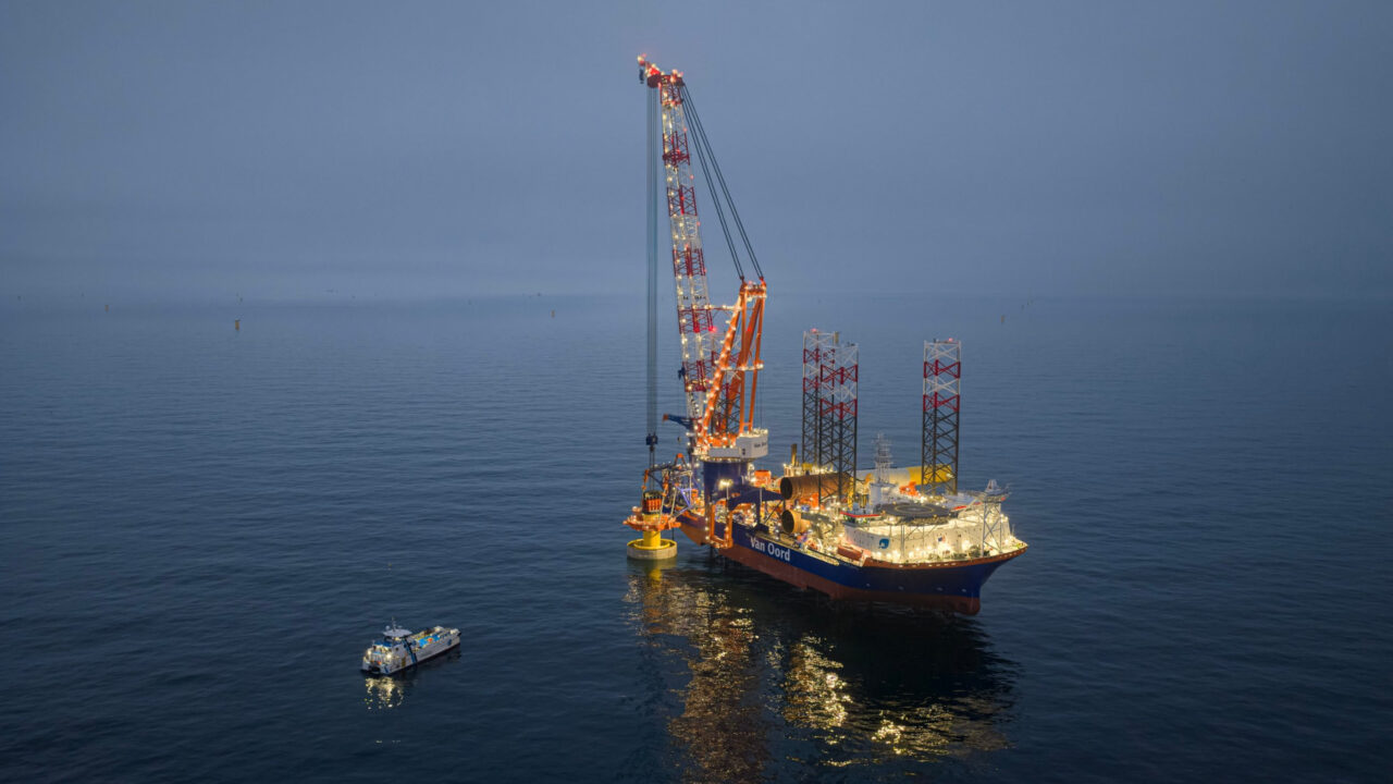 Van Oord installation vessel installing a monopile at sea at dusk